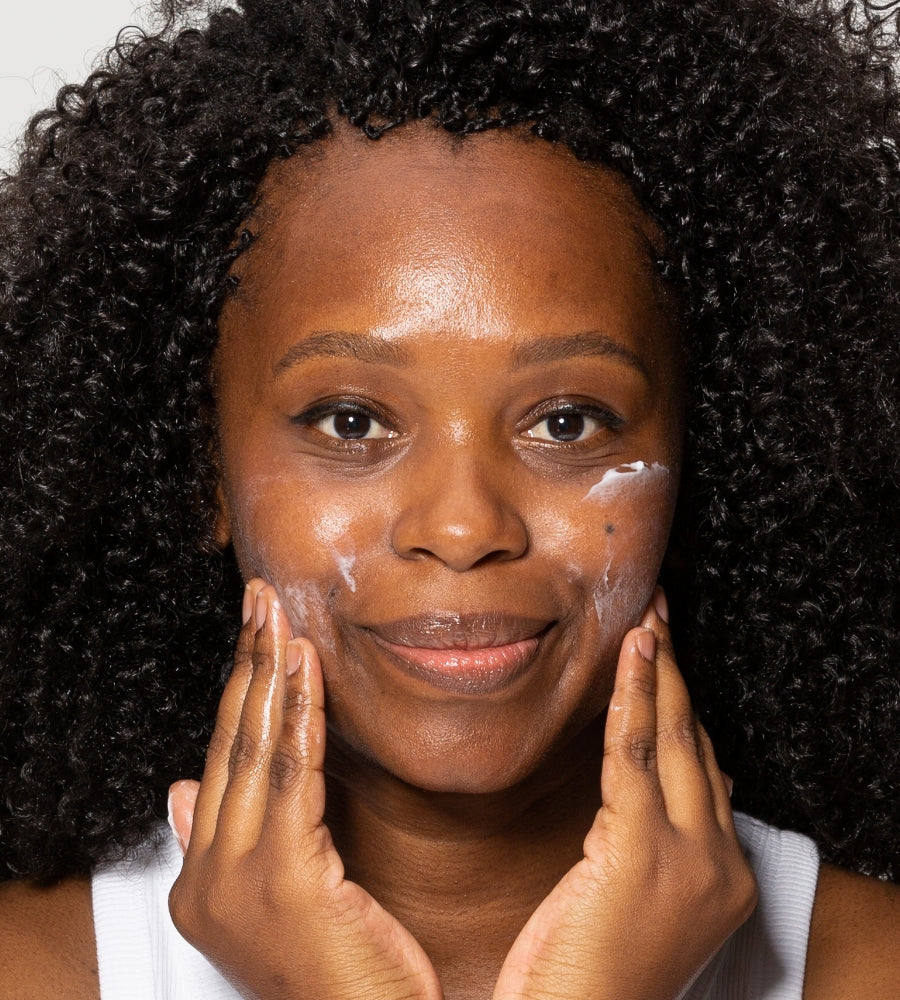 Woman using moisturiser on face in skincare routine