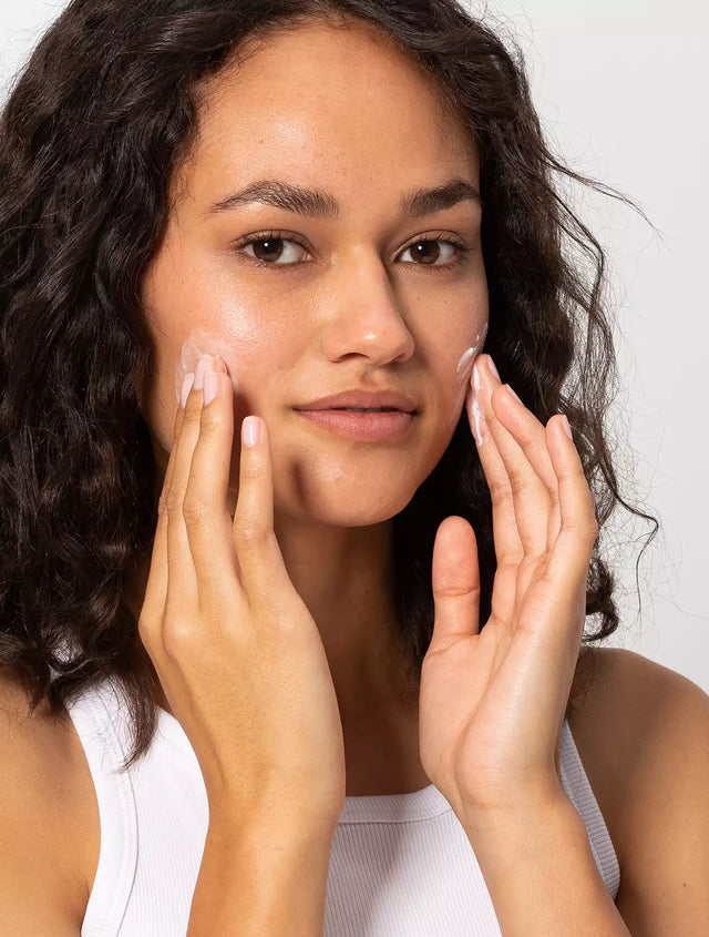 Woman applying day cream to her face