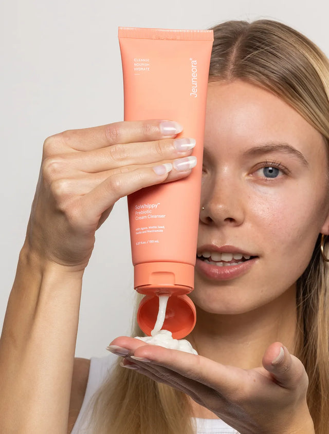 Woman squeezing out SoWhippy face cleanser from tube
