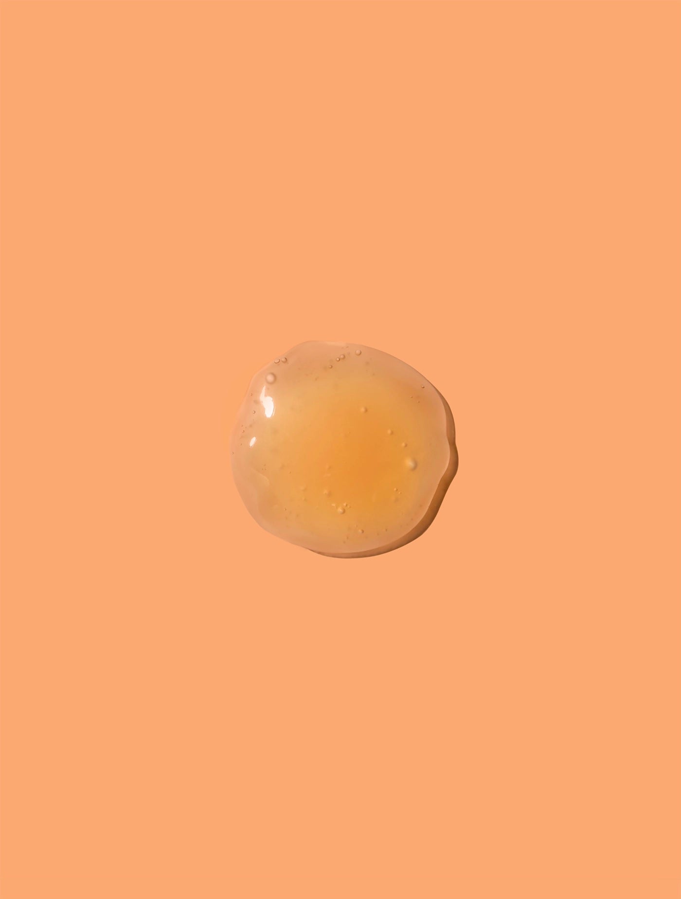 vitamin c serum texture on orange background