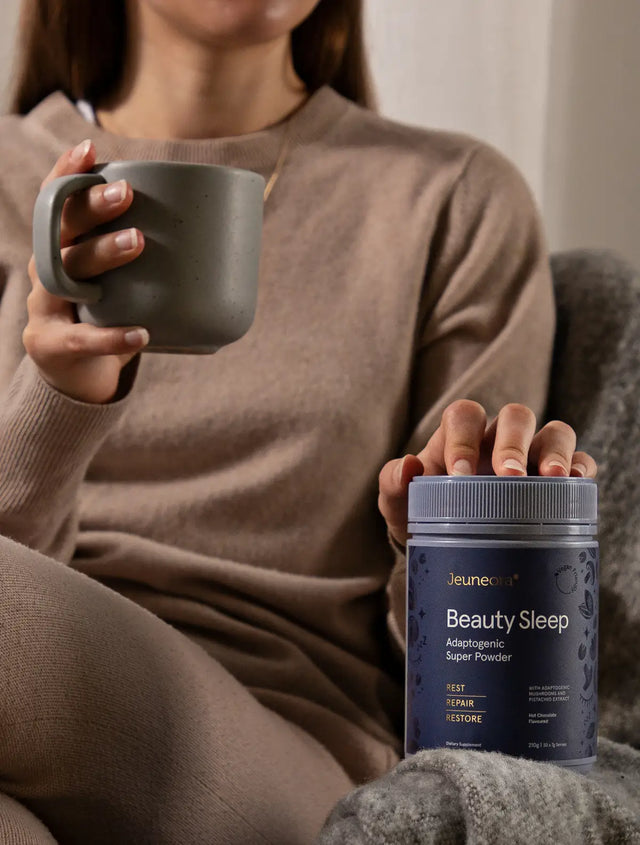 Women sitting in cosy evening set up with a cup of Jeuneora Beauty Sleep Adaptogenic Super Powder