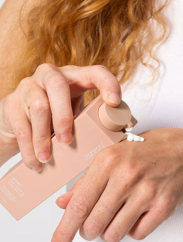 Woman pumping product from skincare serum